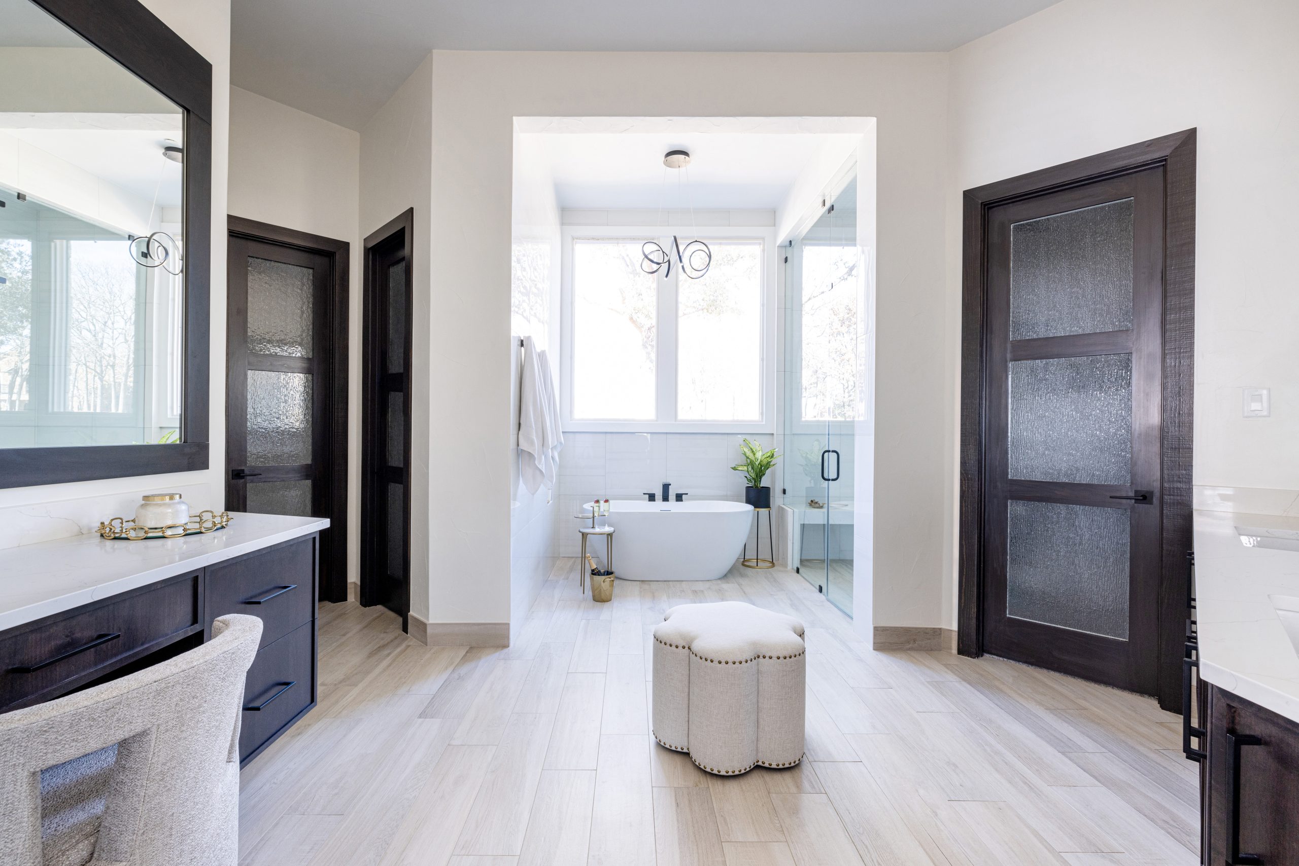 Basler_Bathroom renovation with remodeled steam shower and custom cabinetry and bathtub with eyecandy light fixture and his-and-her water closets in Trophy Club Texas