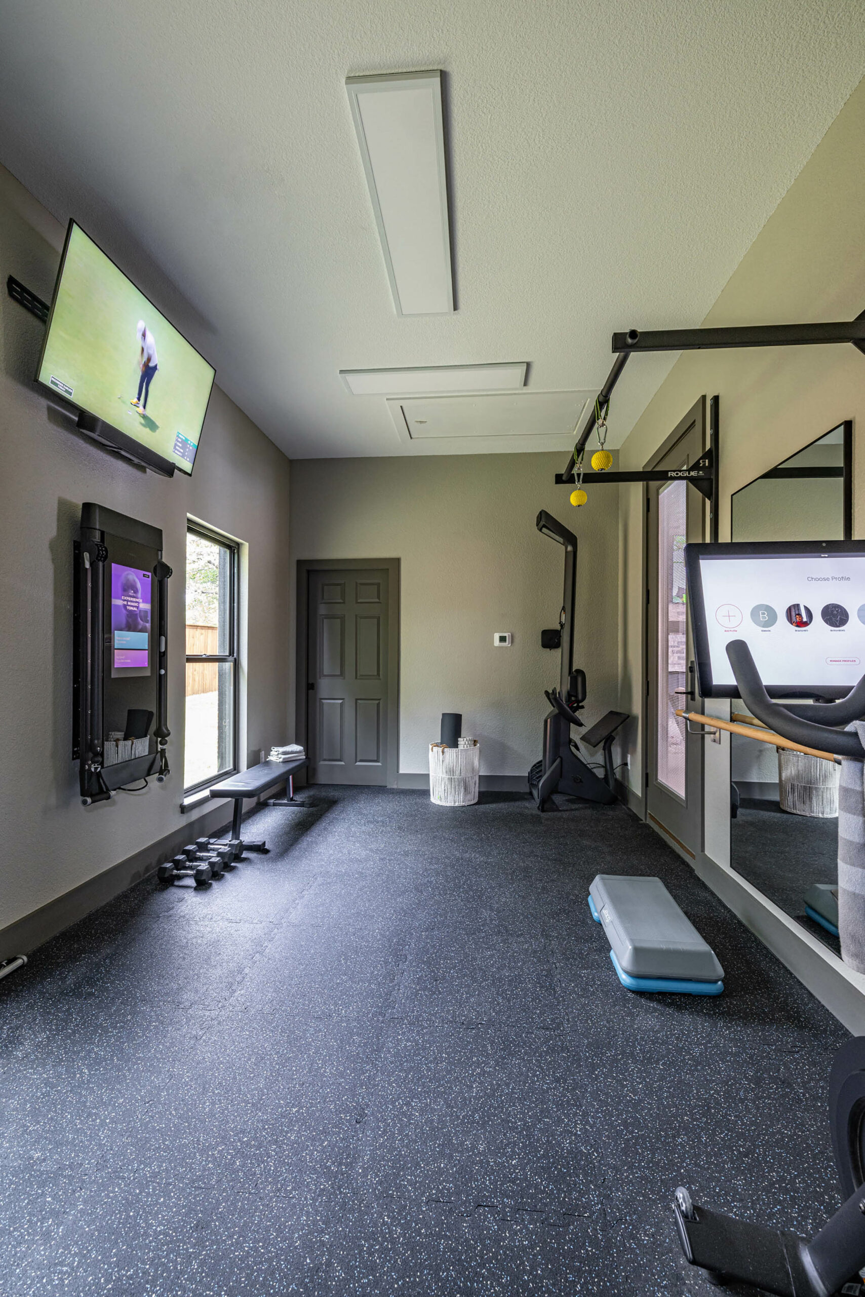 Birkenfeld_Home gym equipped with Peloton and weight station inside of indoor-outdoor pool cabana in Keller Texas