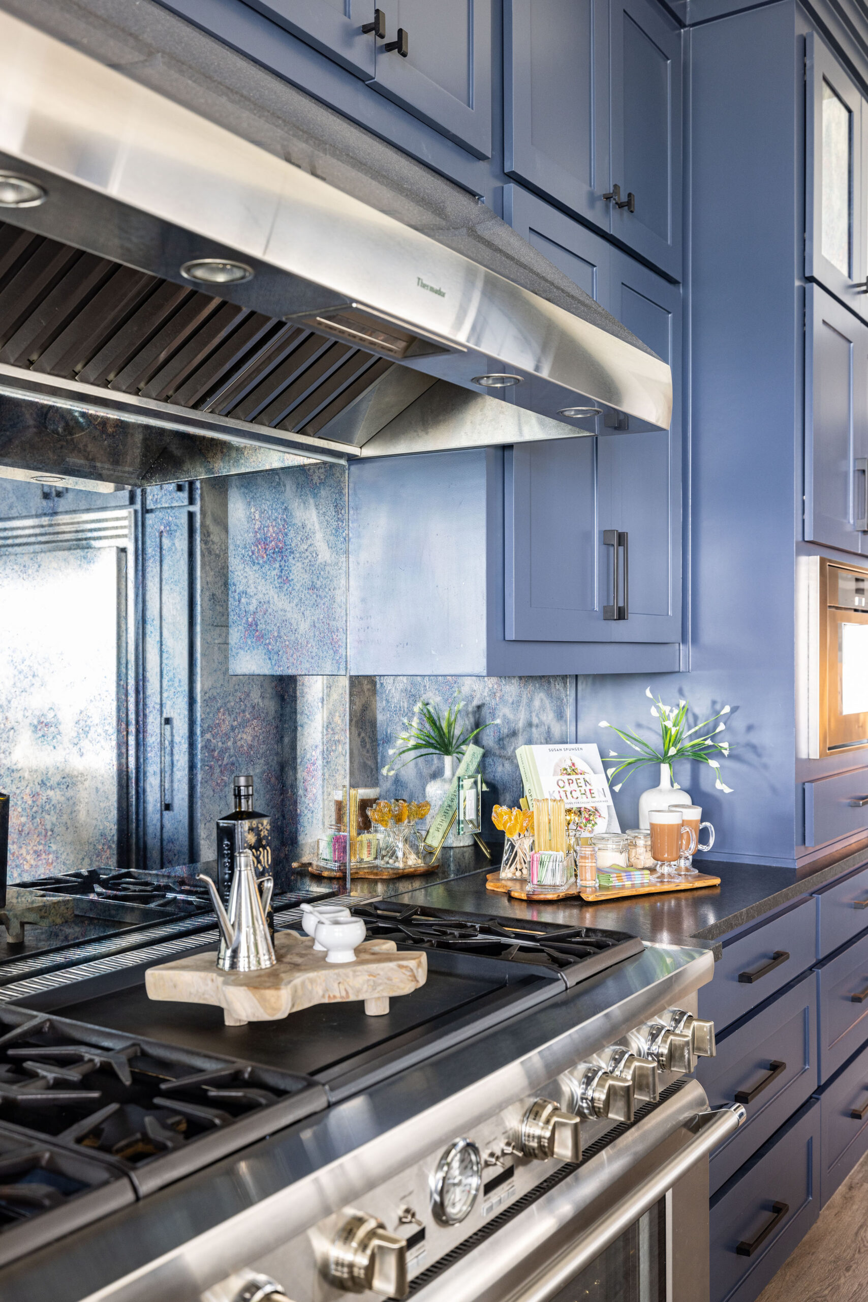 Lake house_Kitchen renovation with custom antique glass backsplash multiple burner stovetop custom oven hood in second home vacation property in Possum Kingdom Lake Texas