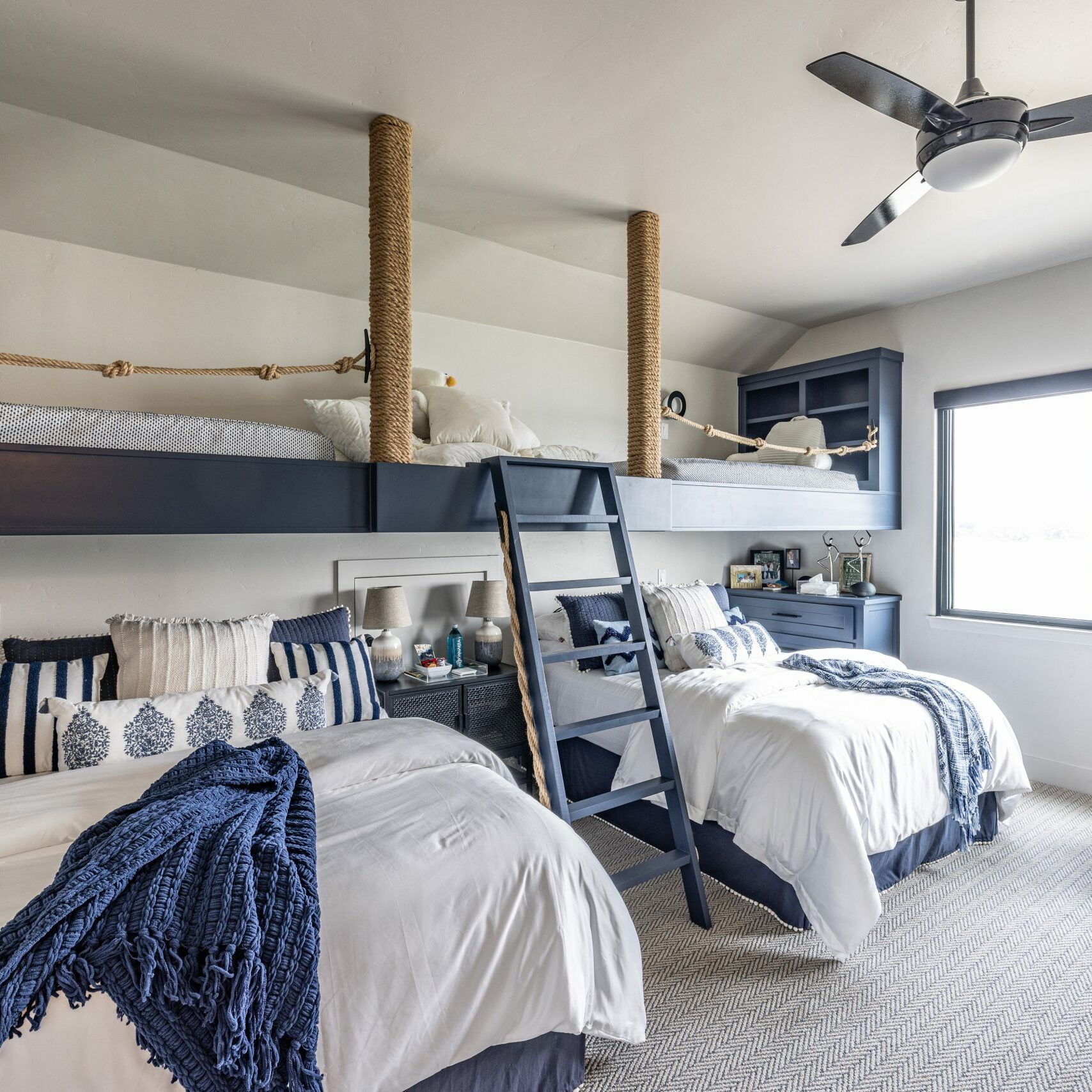 Lake house_Grandkids' room with loft bed and overstuffed bed with fluffy bedding and play area all with a nautical theme in second home vacation property in Possum Kingdom Lake Texas
